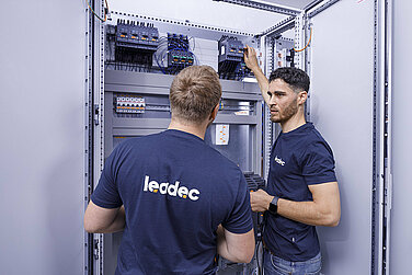 Two Leadec employees checking a switch cabinet.